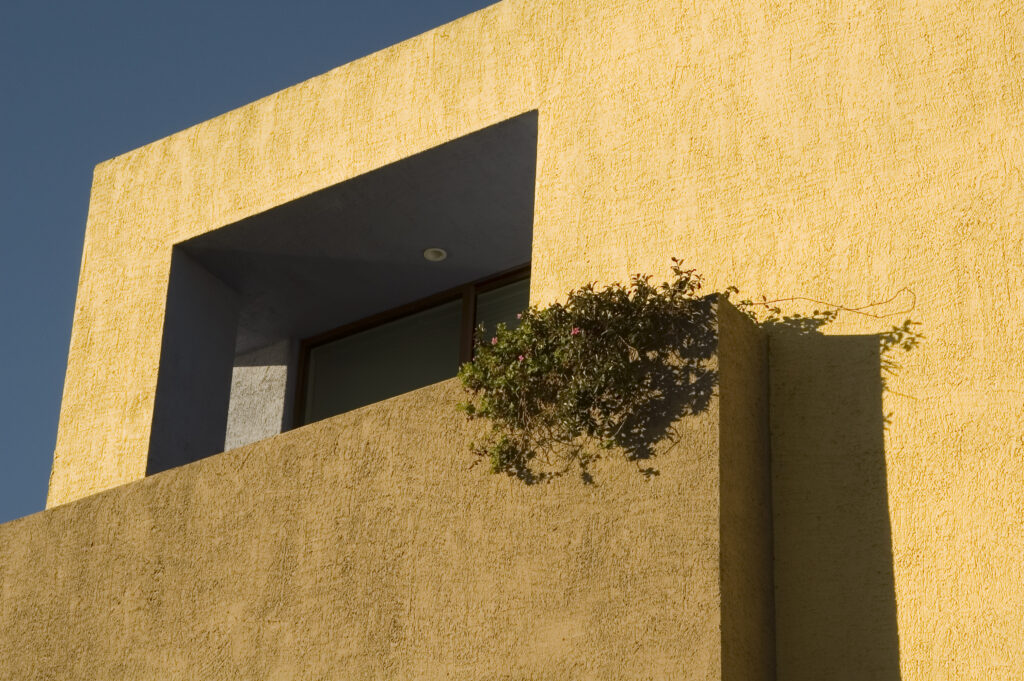 Residential stucco painting on a finished exterior wall